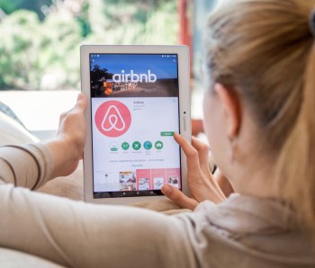 WROCLAW, POLAND- APRIL 10th, 2017:  Woman is installing Airbnb application on Lenovo tablet. Airbnb is an online marketplace and hospitality service, enabling people to lease or rent short-term lodging