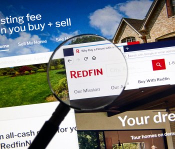 Redfin logo on official site under magnifying glass.