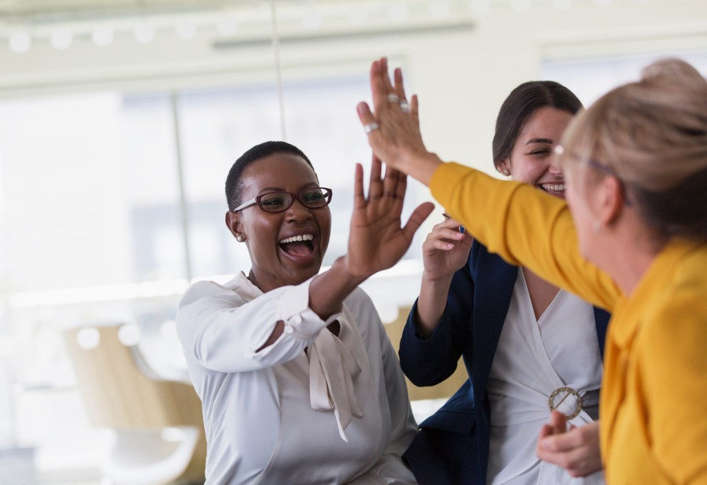 agent teams high-fiving in office