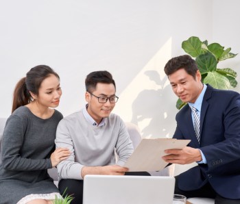 Sales Consultant showing new investment plans to young asian couple
