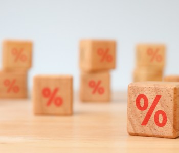 Interest rate financial and mortgage rates concept. Hand choosen wooden cube block with icon percentage symbol